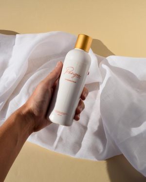 Mano sosteniendo el limpiador facial antiedad de la línea Pangea, cosmética vegana antiedad España